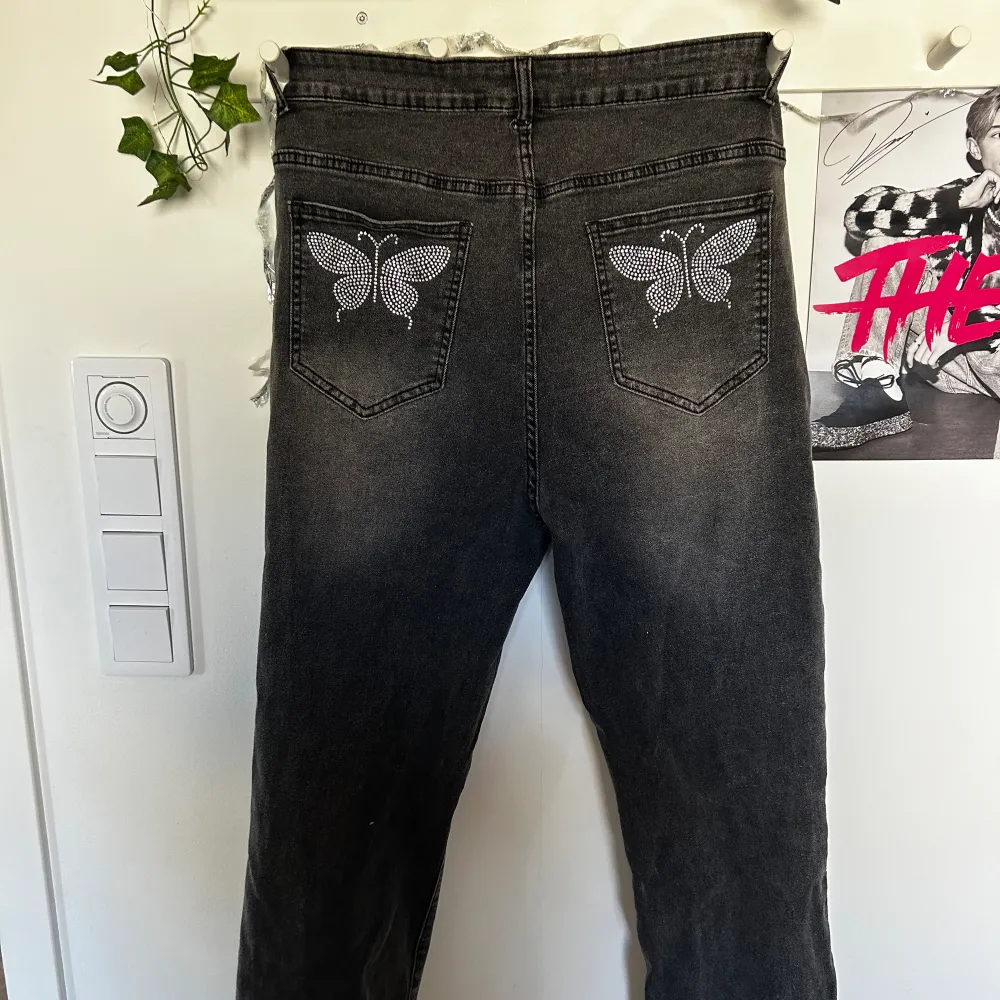 Hej! Jag säljer mina mörkgråa jeans med fjärilar på fickorna för att dom inte passar mig. Ej använda🩶de har slits i smalbenen🩶. Jeans & Byxor.