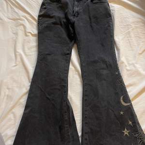 Svarta jeans med broderade stjärnor och månar. Väldigt bekväma, använd ett fåtal gånger, utsvängda ben Nypris 382kr