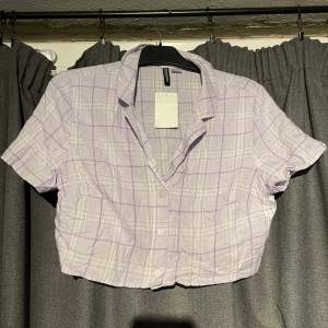 Väldigt kort lila rutig skjorta, aldrig använd helt ny med lapp