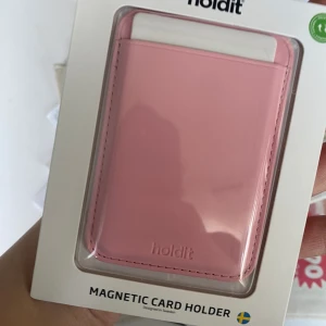 Korthållare till skal - Köpte korthållaren på Holdit för 300 kr.  Villig att sälja för 150-200kr, den är helt ny och är fortfarande i sitt orginal förpackning. Passar alla möjliga typer av skal och mobiler, magneten sätts innanför skalet vilket gör att den håller stadigt.