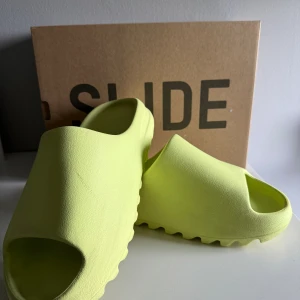 Yeezy Slide - Hej säljer dessa tofflor då de inte kommit till användning så mycket, skick 9/10 de är som helt nya, köpta på soleplus för 2400 (kvitto finns). Mitt pris 1400. Skriv vid frågor eller funderingar, priset kan diskuteras vid en snabb affär, passar 44-45