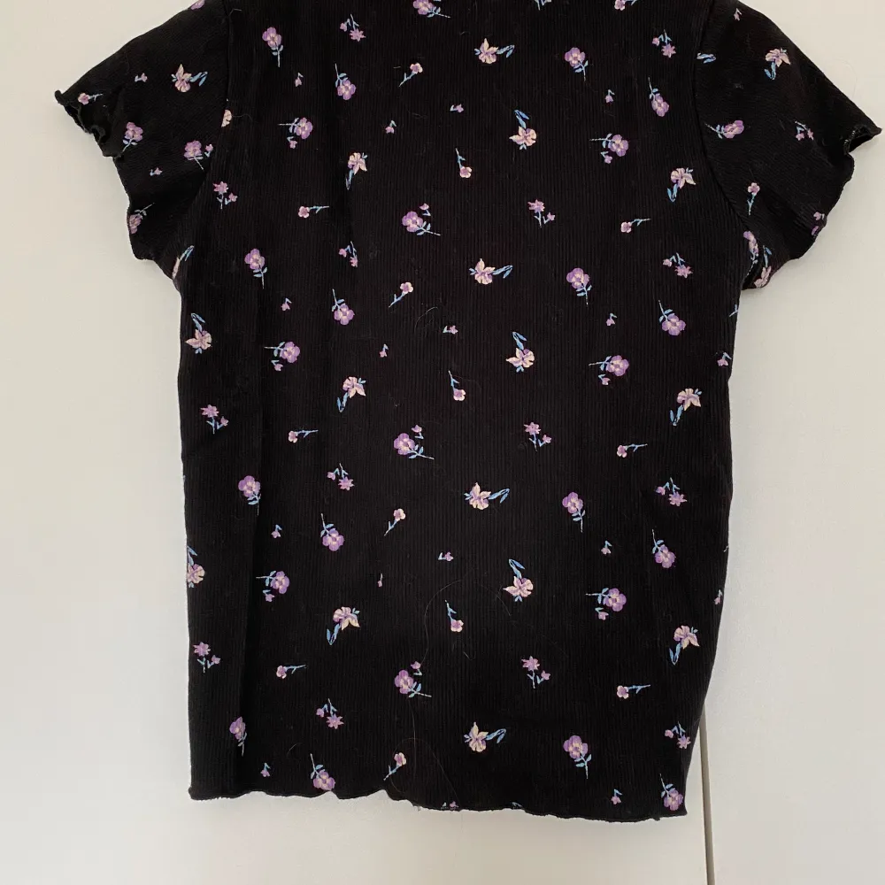 En svart t-shirt med små blommor på från H&M. Toppar.