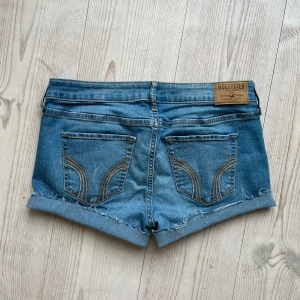 Ljusblå hollistershorts  - Ljusblå lågmidjade jeansshorts från Hollister i storlek W28 L33 som jag har gjort om från ett par byxor. Tvärs över midjan är det ca 39 cm. Passar mig som brukar ha S eller M. Fint skick. Använd gärna köp nu!