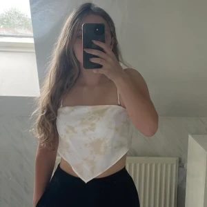 Vit Bandana top/linne - Söt sommartopp med ett marmorerat mönster. Köpt för ett par år sedan men aldrig använt. Banden är justerbara och avtagbara för en off-shoulder look.   Storlek S men är väldigt stretchig så passar nog även på XS och M.