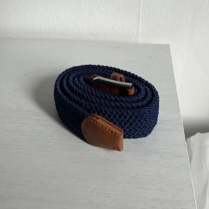 Marinblått flätat bälte - Ett marinblått flätat bälte helt oanvänt och helt nytt. 115cm. För mer info och prisdiskutering kom PM.