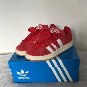 Röda Adidas Campus 00 - Säljer mina älskade adidas skor som jag fick i födelsedagspresent, därför säljer jag för ordinarie priset💕tyvärr var dem för små för mig🥲 Nästan helt nya, använda en gång🫶 original kartong och extra snören i rött och vitt ingår!