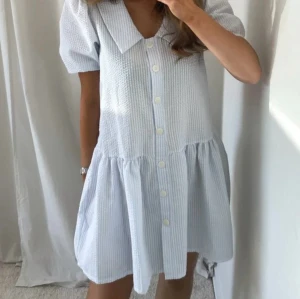 Melina dress - Jättefin vit och blårandig klänning med puffärmar från Noella! Lite större i storleken, passar mig som vanligtvis har S. Nypris är 889kr