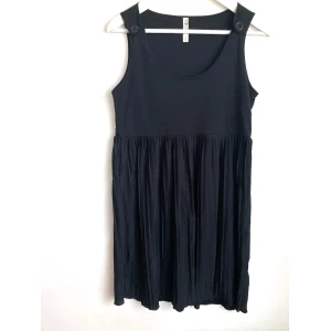 Plisserad svart miniklänning, M 40/42, enkel, ärmlös, stilren, knapp, goth - Svart miniklänning med plisserad kjol. Finns noppor och knappen på höger axel har ett hack. Mått får ej plats - fråga gärna!