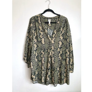 Ormmönstrad tunika, 44 L, blus, djurmönstrad, grön, beige, bohemisk, boho, khaki, brun - Ormmönstrad långärmad tunika, knappar i ärmsluten. Finns en skada i ringningen från vart den varit hopsydd. Mått får ej plats - fråga gärna!