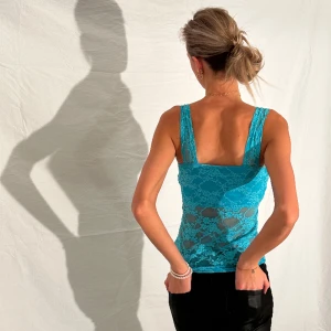 turkost spetslinne - turkos blått linne i spets med stretchigt material. Breda axelband och fyrkantig halsringning.  tjejen på bilden har i vanliga fall xs-s