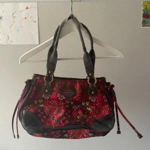Väska - Vintage Oilily väska. Sliten i handtagen och läderområdena. Annars i bra skick. Ett stort och två små fack på insidan. 