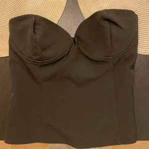Svart korsett topp - Jättefin svart korsett topp från nakd! Använd en gång förra nyår. Storlek 38 men ganska liten i storlek. 