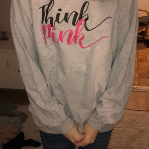 Grå tröja med svart och rosa text - Det är en grå tröja med en text där de första står i svart och de står think och sen i rosa och där står det pink
