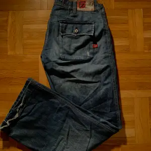 Lågmidjade och baggy retro jeans med straight leg🙌 Köpta second hand men fortfarande i fint skick. Snygga fickor med knappar som detaljer. Fraktkostnaden är exluderar från priset. 
