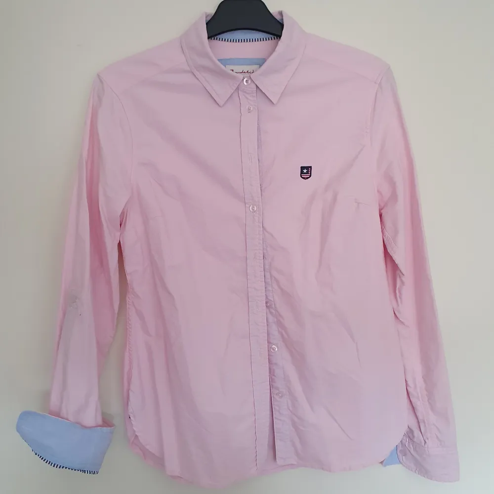 Rosa skjorta från Bondelid, använd men i bra skick. Inga fläckar eller slitage. Gjord för att kunna vika upp ärmarna, finns knapp att fästa med.. Skjortor.