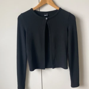 Svart stickad cardigan  - Säljer denn helt nya oanvända kofta med en knapp från Gina. Säljer då den aldrig kommit till användning. Nypris 300kr. 
