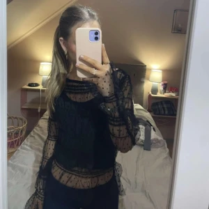 Svart festlig topp - Svart blus/topp i mesh med volang/prickar och små paljetter! As snygg! Aldrig använd så i toppskick:) Storlek S🥰🥰🥰🥰🥰