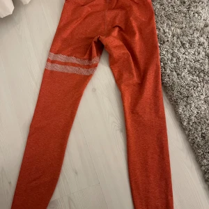Stronger tights  - Tights från Stronger, på bilden ser de lite oranga ut men kolla sista bilden för att se bättre mot vitt! Skada som man ser på andra bilden men inget som syns på! Midjemått runt 60 an och innerbens längd runt 65 cm. Skriv för mer information!