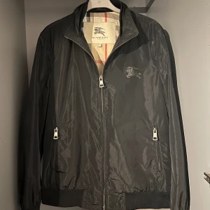 Burberry Jacka - En riktigt skön Burberry jacka. Svart i utsidan men färgan innanför (den går ej att vända ut och in!!). Kvitto finns tyvär inte, dock är den i bra skick. Vid mer frågor skriv gärna. Byten kan funka samt pris diskuteras vid snabb affär👍🏽