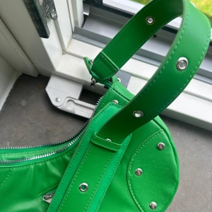 Grön crossbody väska!  - Använd fåtal gånger från HM.  Går att få i det mesta och finns två fack med dragkedja. 