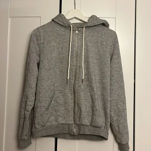 Hoodie med dragkedja  - En grå hoddie med dragkedja 