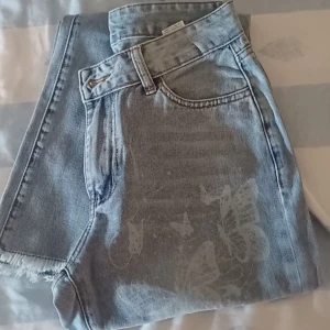 Jeans med tryck - Ljusblåa jeans med vit fjärilstryck, jätte söta men är dock lite för långa på mig. De är bootcut/flare