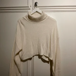 Stickad polotröja  - Äggskalsvit stickad tröja med polokrage. Relativt croppad passform. Använd ett antal gånger men är i mycket bra skick. 