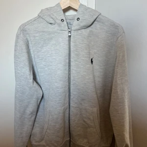 Grå Polo Ralph lauren zip up - Säljer min Ralp lauren hoodie i storlek s men den passar m bättre. Bra skick men inga snören i och använd i någon månad bara. Pris: 700 men kan diskuteras lite 