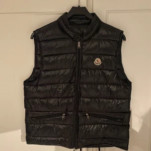 Moncler Gui - Väst - Säljer nu en Moncler gui väst. Sjukt snygg till våren. Storlek M. Påse finns med. NFC Scan funkar.  Pris kan diskuteras vid snabb affär.  