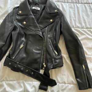 Svart skinnjacka  - Säljer denna svarta skinn jackan från Nelly som är helt oanvänd. Jackan har väldigt fina detaljer med dragkedjor. 