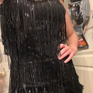 Glitter klänning med detaljer - Glittrig klänning med fjädrar nertill, använd endast 1 gång. Den är köpt i Spanien därav vet ej märke , även storlek står inte men jag är vanligtvis en S-M och denna sitter perfekt, hör av er vid frågor o funderingar 🙌