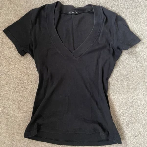 T-shirt/topp - Supersnygg unik t-shirt med v-ringning som är köpt second hand på Humana. Säljer då det ej kommer till användning. Skriv för fler bilder💕. 