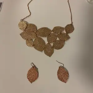 Örhänge samt halsband som ser ut som löv. Är guld/roséguld i färgen. Säljes helat tillsammans men kan säljas var för sig också.