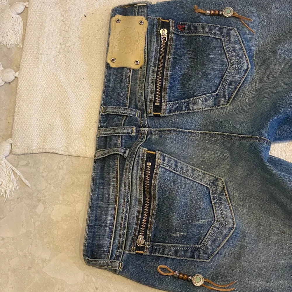 Mörkblåa lågmidjade jeans. De har snygga detaljer på bakfickorna, man kan även sätta dit ett par detaljer som jag valde att ta bort, man kan se på första bilden. Har använts fåtal gånger och är i perfekt skick!! De är raka och har storleken W30 L32. . Jeans & Byxor.