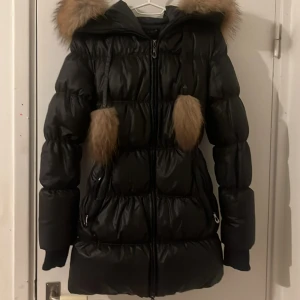 Svart vinterjacka - Hollies jacka storlek 36. Knappt använd är som nu. Har äkta päls. Är i medellängd, precis över rumpan.
