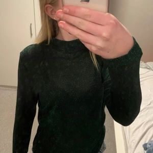 Glittrig topp  - Grön, glittrig tröja med halvpolo från only. Helt ny med lappen kvar. Köpt på only. (nypris är 150kr)