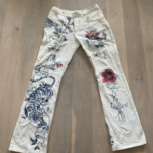 Low waist jeans - Vita låg midjade jeans med fin design på, storleken på byxorna står L men jag har storlek S och de är bara en aning för stora 