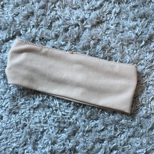 Hårband - Beige hårband. Aldrig kommit till andvändning.