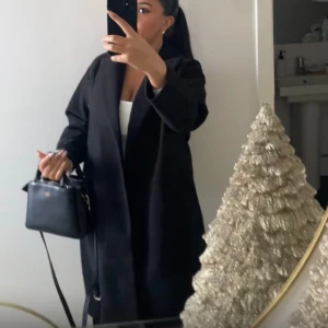 Svart kappa från veromoda - Säljer min fina kappa med skärp som jag haft i 3 månader. Säljer pga rensning av garderoben. Storleken är xs men passar folk som bär s-m. Köptes för 639. Inga fel med den.