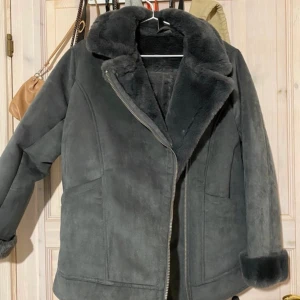 Kappa med fuskpälsfodring - Jättefin grå kappa jag köpte. Bild är från förra säljaren, den var tyvärr för stor. Den är i  nyskick och med jättemjuk fuskpäls vid ärmarna och på insidan :) 
