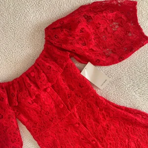 ZARA röd romantisk spetsklänning - Otroligt vacker klänning från ZARA i röd spets med knappar längs med bysten. Storlek XS men väldigt stretchig och passar även S. Midi-längd till knäna. Perfekt för alla hjärtans dag 🌹 Ny med tags kvar, utan anmärkningar.