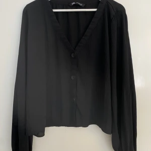 Zara blus  - Svart plisserad blus från zara. Smått plisserat längst upp vid blusen som sedan blir större plisseringar längst ner på blusen. Inget slitage eller fläckar 