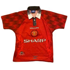 Manchester Uniteds officiella hemmatröja från 1996 i nästintill nyskick. Tröjan är i ”youth” storlek men uppskattas till XS herr.   Mått: 63 x 48