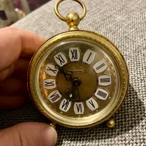 En liten guldig väckarklocka med vackra vintage mönster. Funkar fint som prydnad eller inredning också! Alarmklockan funkar galant!