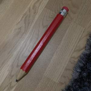 En stor röd penna som knappt har använts. Den funkar bra och är rolig för speciellt yngre barn. Det kan vara roligt att ge som en present till någon eller att ha för sig själv.