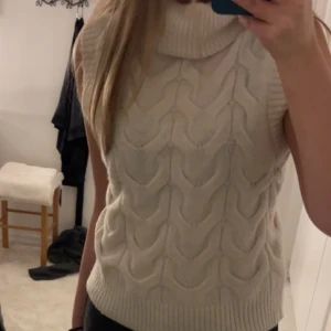 Stickad polotröja - Jättefin stickad polotröja i vit utan ärmar. Använd ett fåtal gånger💕
