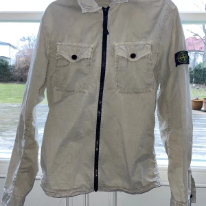 Stone Island Overshirt - Stone Island Overshirt i beige färg Skick 9/10 ändast använd fåtal gånger. Såklart äkta, som man ser på tredje bilden. Perfekt för våren. Skriv gärna om du har frågor!