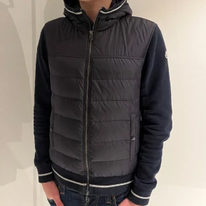 Moncler Cardigan - En riktigt snygg moncler cardigan där skicket är utmärkt!  Storleken är L men den sitter mer som en M.  Han på bilden är 182 och väger 75 kg.  Hör av er vid minsta lilla fundering!😀