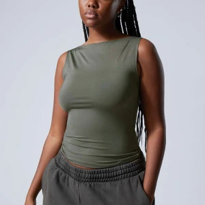 Weekday topp khaki  - Den populära toppen ”Annie Boatneck Sleeveless Top” från Weekday i en khaki-grön färg. Superfint skick (använd endast ett få antal gånger) och i storlek M. Säljer då den inte kommer till användning!