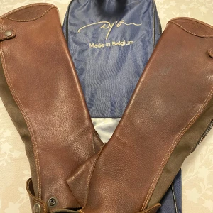 Dy’on chaps - Ett par Dy’on chaps som nästan aldrig blivit använda. Köpta för 2500kr. Superfina och sköna men jag själv använder bara stövlar. Finns fler bilder. Dem är 34 centimeter där dem är som bredast Och längst ner är dem 28 centimeter. Dem är 45 cenitmeter 